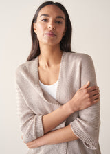 Woman wearing greige open knit relaxed cardigan and leopard print torusers