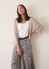 Woman wearing greige open knit relaxed cardigan and leopard print torusers
