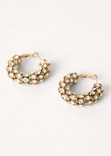 Large crystal hoop gold earrings on white background
