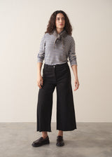 Woman wearing striped sweater and black wide leg cropped trousers
