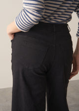 Woman wearing striped sweater and black wide leg cropped trousers