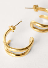 Close up of gold double hoop earrings on white background
