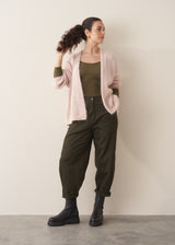 Woman wearing a khaki green top and dark green barrel leg trousers