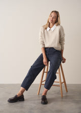 Woman wearing a white cropped linen shirt and navy barrel leg trousers