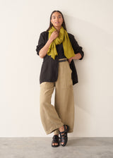 A woman wearing like green linen wide leg cargo trousers and a black t-shirt
