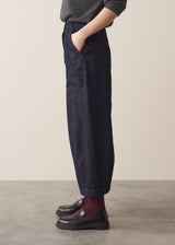 Woman wearing a grey sweater and dark blue wide leg cargo jeans and brown loafers