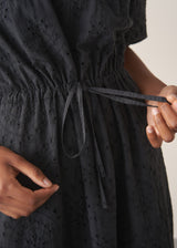 Close up of tie string detail on a black maxi broderie dress