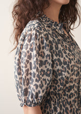 Woman wearing grey leopard print dress and nude sandals