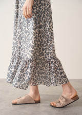 Woman wearing grey leopard print dress and nude sandals