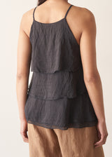 Woman wearing black layered halter top with brown linen trousers