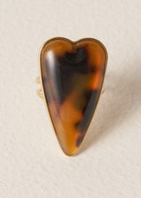 Tortoiseshell ring with gold ring on a beige background