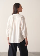Woman wearing white cotton shirt with black trousers