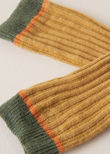 close up of folded heavy knit socks in a mustard yellow wool blend, with retro orange and green ankle stripes