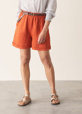 Woman wearing striped shirt and red linen shorts with sandals