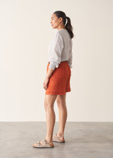 Woman wearing striped shirt and red linen shorts with sandals