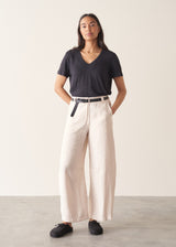Woman wearing grey v-neck t-shirt and off white barrel leg trousers