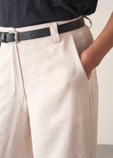 Woman wearing grey v-neck t-shirt and off white barrel leg trousers
