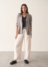 Woman wearing grey v-neck t-shirt and off white barrel leg trousers