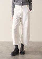 Person wearing grey cardigan and white denim barrel leg jeans