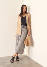 Woman wearing beige blazer with stripe trousers and a black top