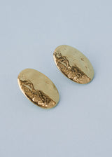 Gold hammered stud earrings on blue background