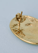 Close up of stud on gold hammered earring