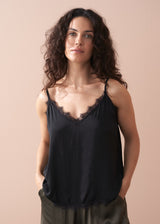 Woman wearing a black satin camisole with lace trim