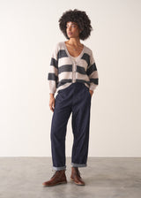 Woman wearing a striped mohair cardigan with a plain background