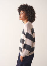 Woman wearing a striped mohair cardigan with a plain background