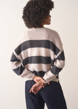 Woman wearing a striped mohair cardigan with a plain background
