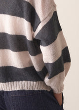 Woman wearing a striped mohair cardigan with a plain background