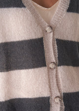 Woman wearing a striped mohair cardigan with a plain background