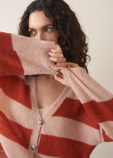 Woman wearing a red and blush pink striped cardigan