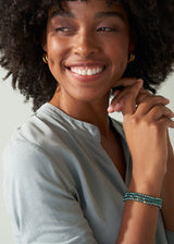 Woman wearing a blue crystal bracelet with blue blouse