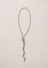 Gold chain knot necklace on a beige background