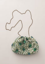 Green embroidered sequin clutch bag with silver chain, on beige background