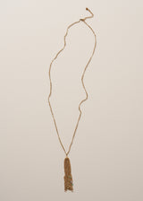 A long chain necklace with gold beads, finished with a multi-strand pendant, and colourful crystals