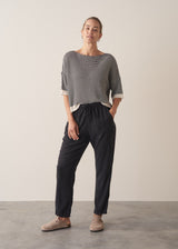 Woman wearing stripe sweater and black tapered drawstring trousers