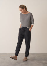 Woman wearing stripe sweater and black tapered drawstring trousers