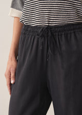 Woman wearing stripe sweater and black tapered drawstring trousers