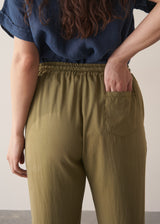 Woman wearing olive green trousers and blue linen shirt