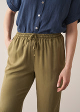 Woman wearing olive green trousers and blue linen shirt