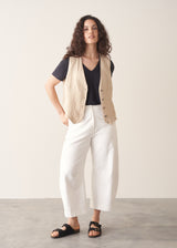 Woman wearing dark grey linen v-neck t-shirt and white jeans