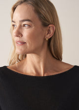 Woman wearing black short sleeve fine knit sweater and leopard print trousers