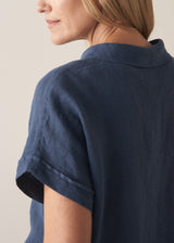 Woman wearing a navy blue short-sleeve linen shirt
