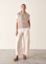 Woman wearing space dye knitted vest top with white t-shirt and light trousers