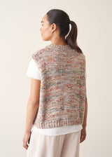 Woman wearing space dye knitted vest top with white t-shirt and light trousers