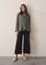 Woman wearing a khaki linen blazer and barrel leg linen trousers