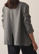 Woman wearing a khaki linen blazer and barrel leg linen trousers