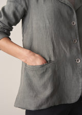 Woman wearing a khaki linen blazer and barrel leg linen trousers